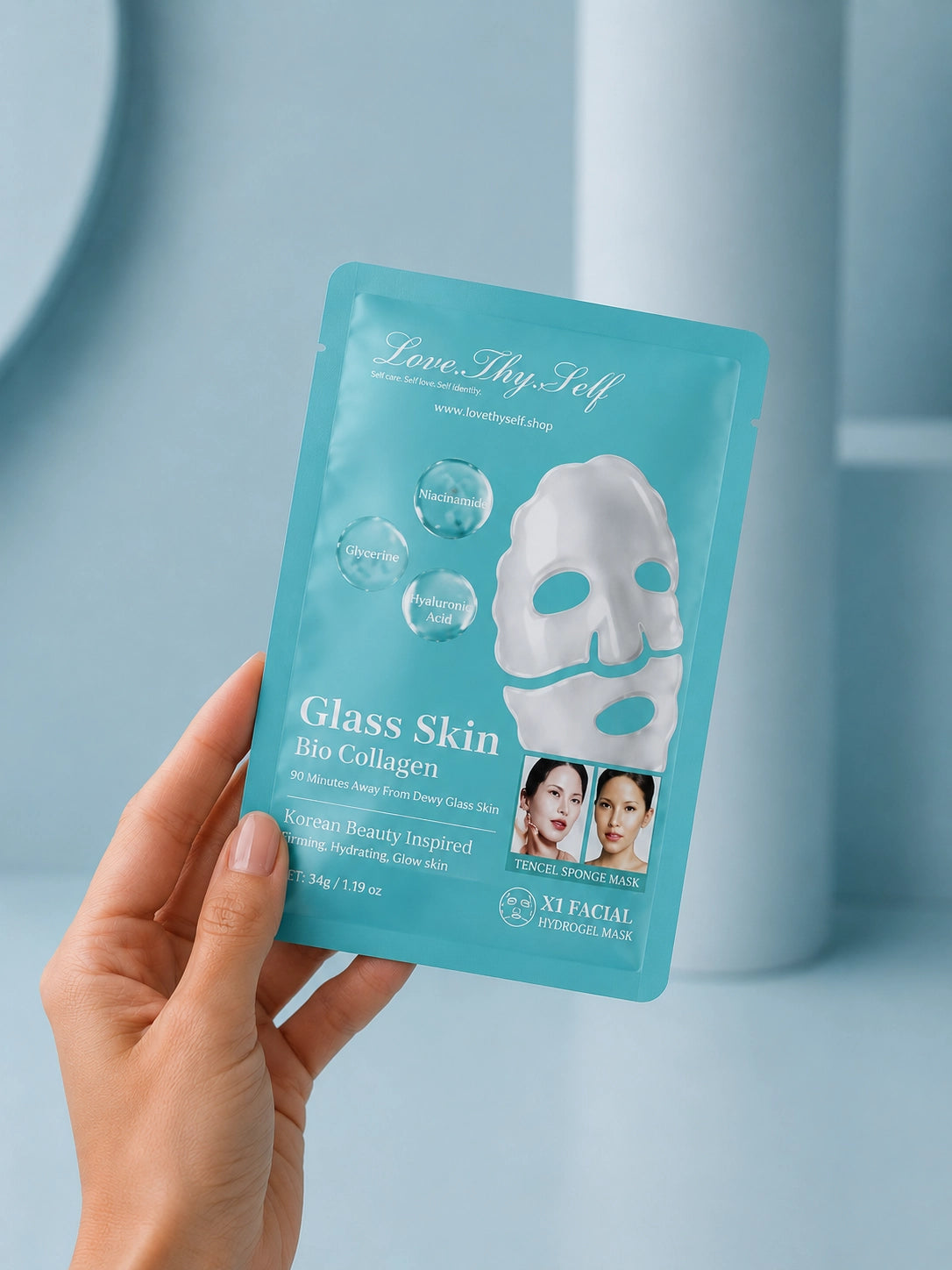 Hand holding a 'Glass Skin Bio Collagen' facial mask package against a light blue background