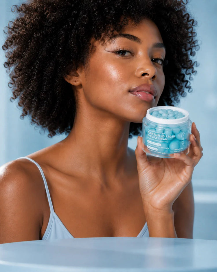 Model holding LoveThySelf PDRN Blue Collagen Capsule Cream with healthy, glowing skin against a light blue background.