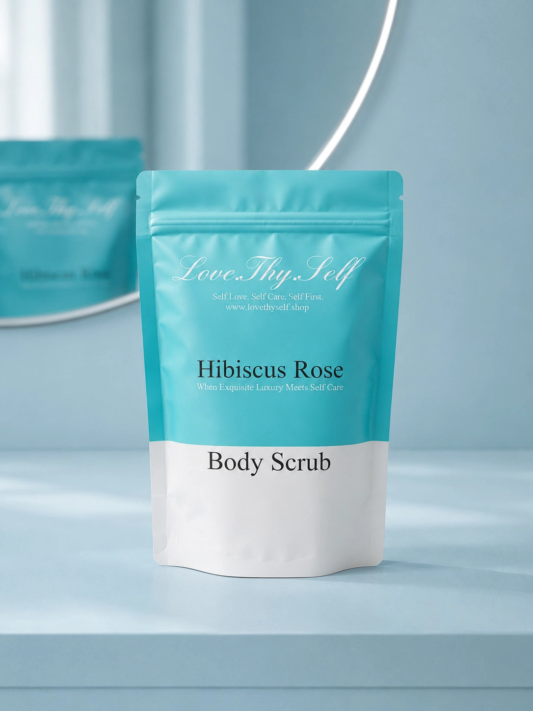 Hibiscus Rose Body Scrub packaging displayed on a light blue vanity with mirror reflection